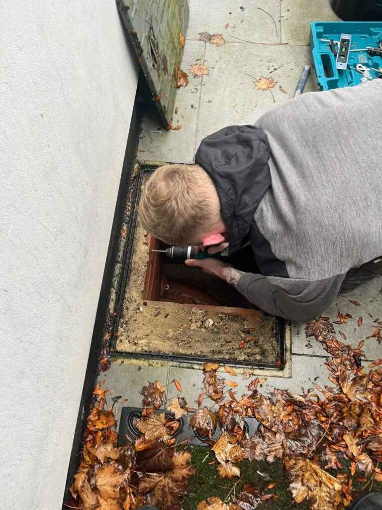 Pest control technician inspecting under floorboards in a Hornchurch home